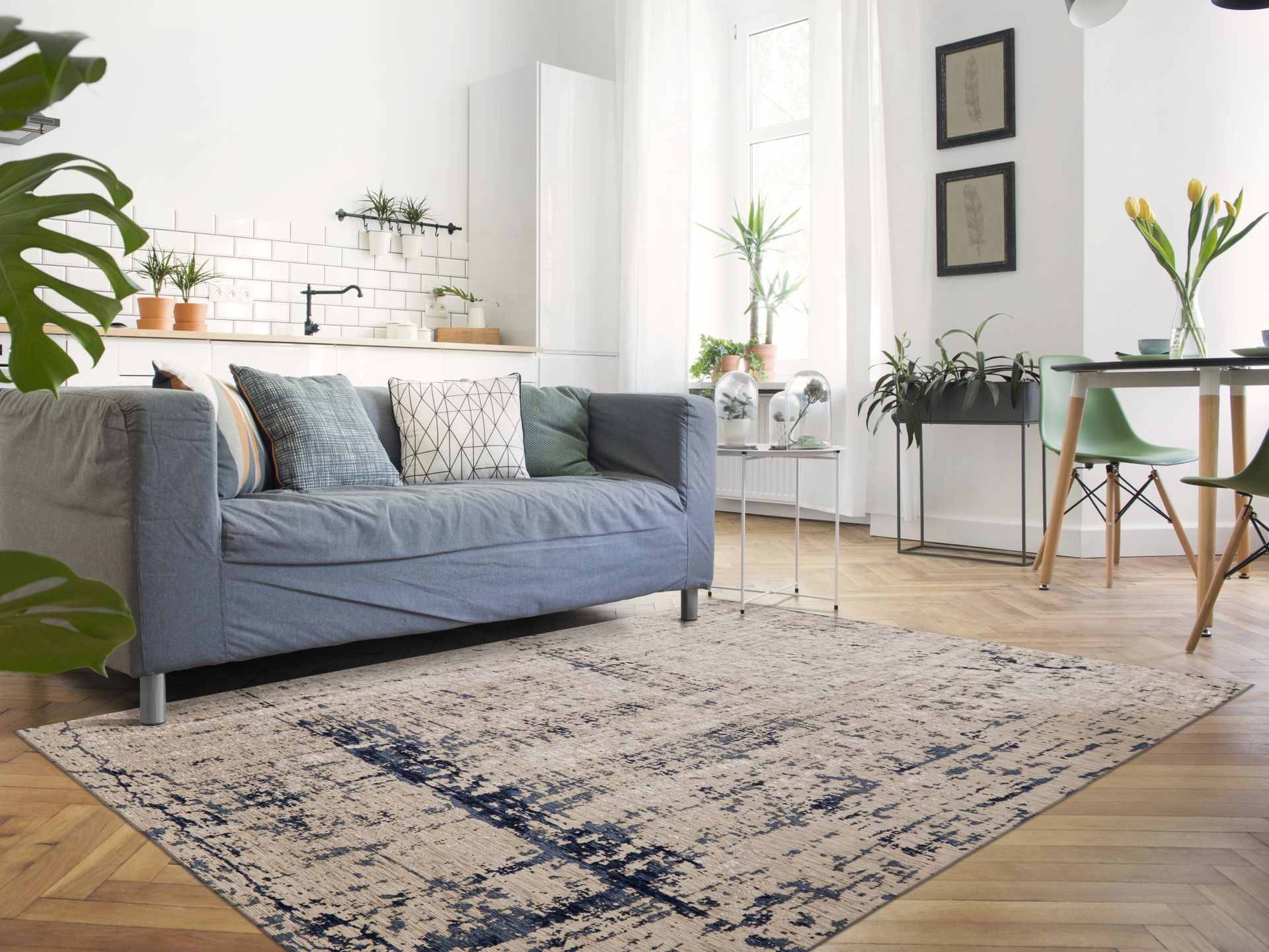 Photo of a vintage-look chenille rug in blue in front of a blue couch.