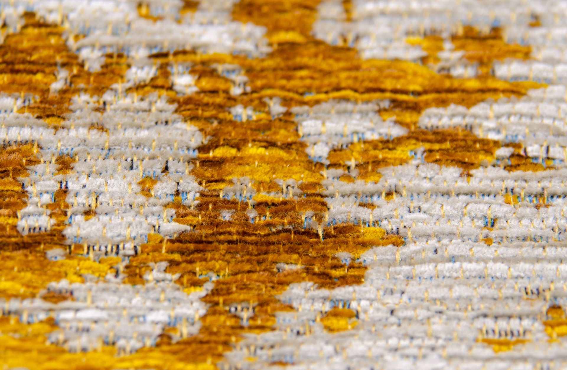 Nachaufnahme eines Chenille-Teppichs in Farbe ocker.